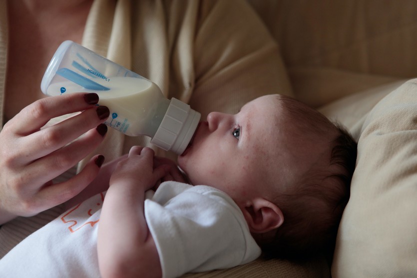 Baby trinkt Milch aus Flasche